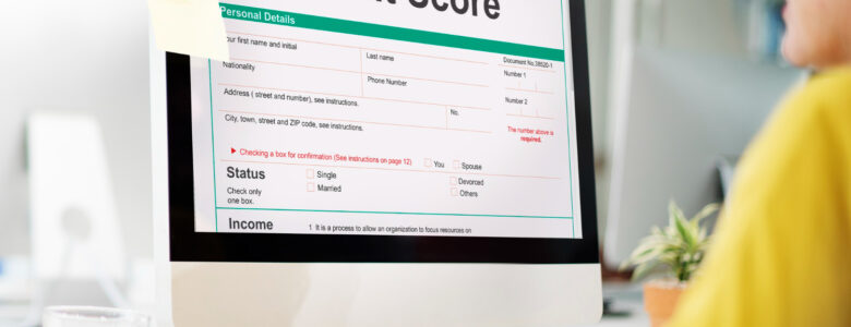 A person reviewing a credit score report on a computer screen, highlighting personal details and credit status information.